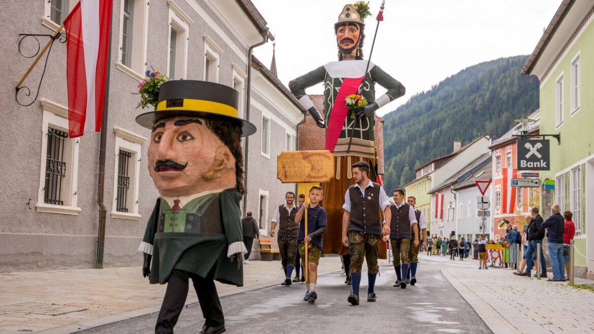 Obr Samson s neodmyslitelným doprovodem trpaslíka putuje uličkou v Tamswegu. Doprovází je spousta lidí, kteří si užívají tento jedinečný, regionální zvyk.