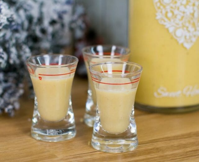 Tři skleničky krémově žlutého vaječného likéru.