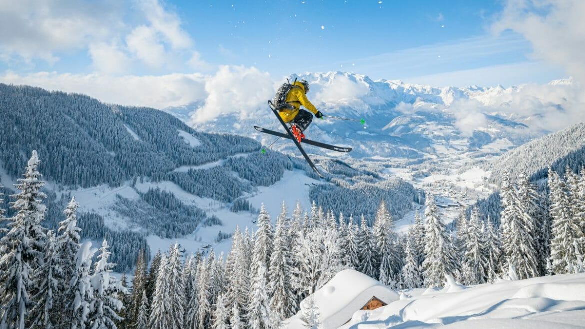 Freeski lyžař nad zasněženým údolím Werfenwengu v Sankt Johann im Pongau
