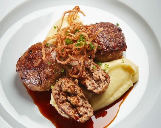 Hauptgericht Werlberger Hlavní chod v podobě jemné bramborové kaše s tennengauským masem, silnou hovězí omáčkou, posypané smaženou cibulkou a petrželkou