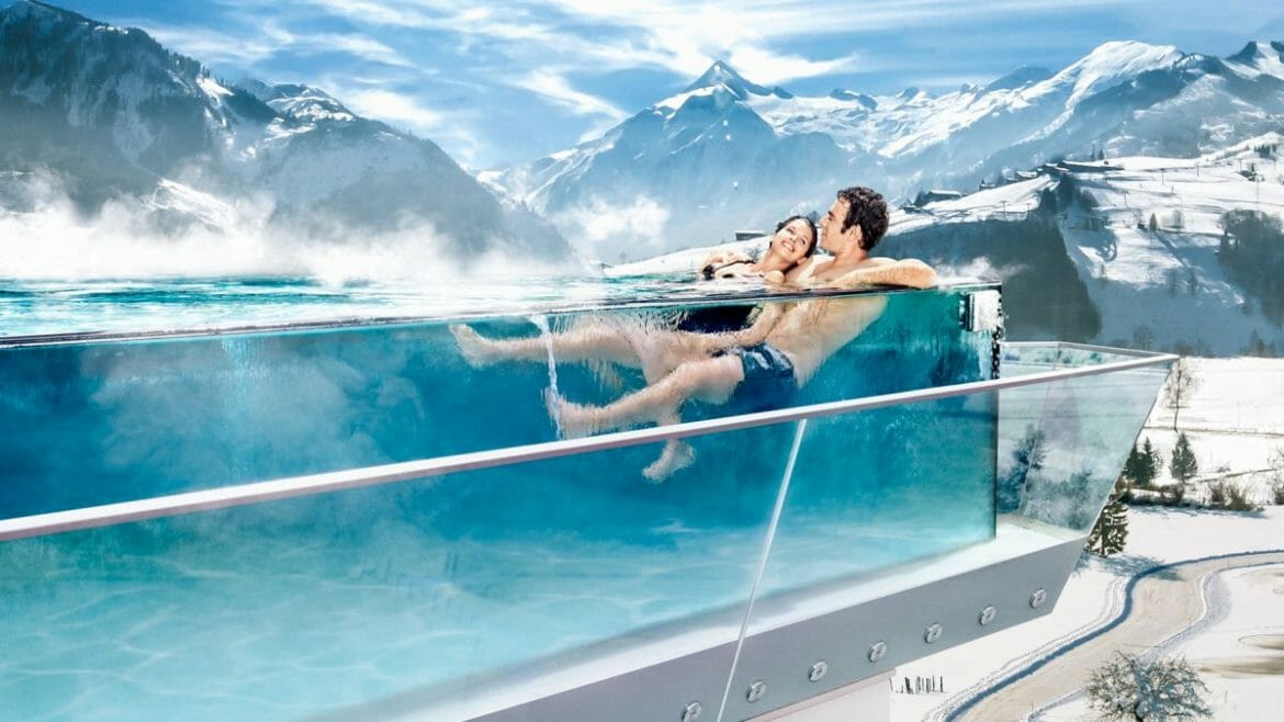 Relaxace v panoramatickém bazénu s termální vodou s výhledem na zasněžené vrcholky Alp v okolí Zell am See-Kaprunu