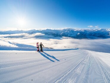 Dva lyžaři na upravené sjezdovce v Salcbursku, ideální pro kurz lyžování nebo Zimní rodinná dovolená.
