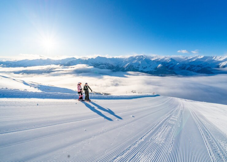 Dva lyžaři na upravené sjezdovce v Salcbursku, ideální pro kurz lyžování nebo Zimní rodinná dovolená.