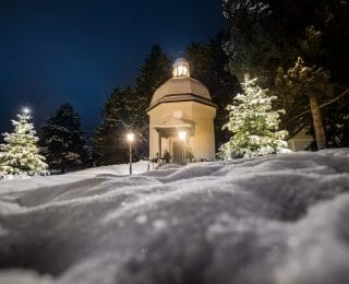 Krásně osvětlená Kaplička Tiché noci v zimní krajině Oberndorfu