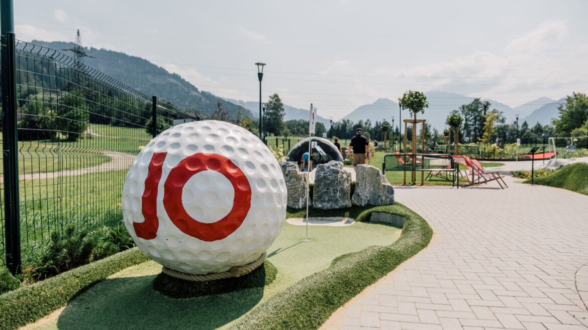 Obří golfový míček s desítkou u minigolfového hřiště ve Svatém Janu v Salcbursku, v pozadí hory.