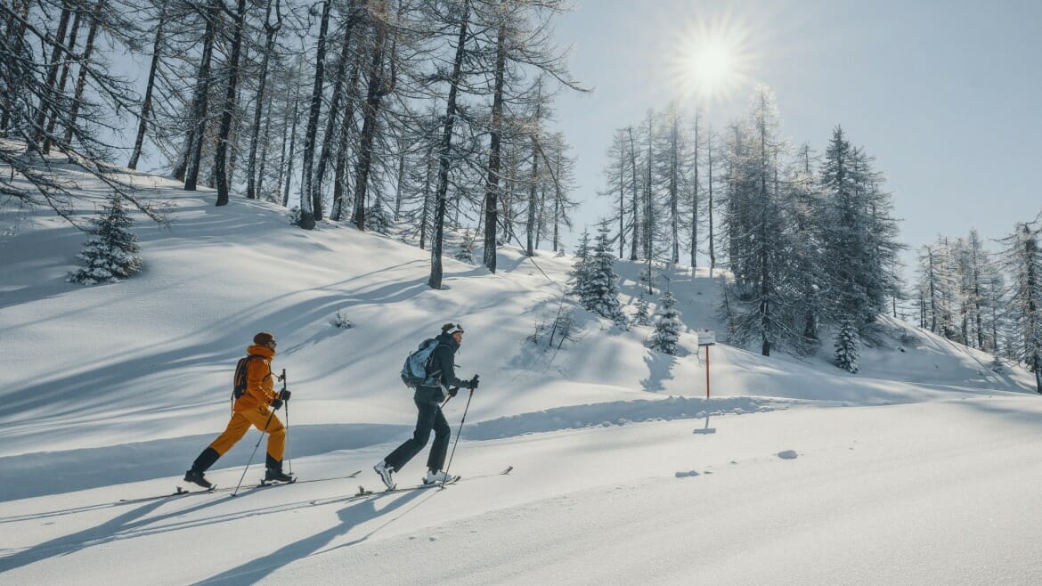 Lyžaři se vydávají na túru po zasněženém kopci v St. Johann v Salcbursku