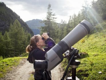 raurisertal-sommer-wandern-krumltal-geierbeobachtung-ctvb-rauris-fotograf-florian-bachmeier-1920×1067 Žena s dalekohledem na lesní stezce v Krumltalu pozoruje supy