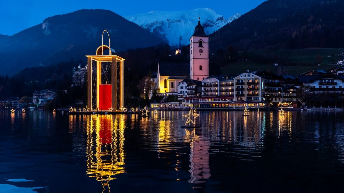 Hladina jezera Wolfgangsee v Salzkammergut je osvětlená velkou lucernou míru, která svítí do dálky