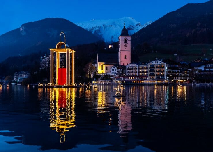 Hladina jezera Wolfgangsee v Salzkammergut je osvětlená velkou lucernou míru, která svítí do dálky