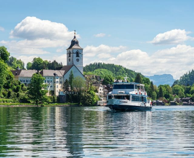 WolfgangseeSchifffahrt MS Salzkammergut Copyright Salzburg AG Pohled na městečko St. Wolfgang okolo kterého pluje po jezeře Wolfgangsee loď na plavbě