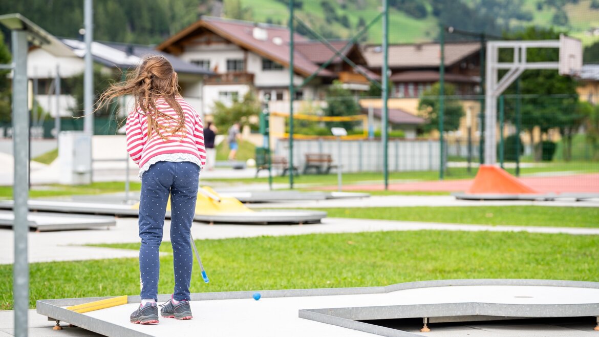 Minigolf v Großarltalu © Tourismusverband Großarltal
Dívka si užívá minigolf pod širým nebem v Grossarltal v Salcbursku v létě a je připravena za slunečného dne odpálit modrý míček. (Zvětšený pohled)