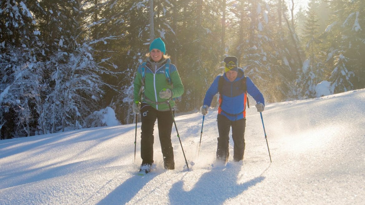 Dvojice putuje na okraji lesa v Salcburském Saalachtalu na sněžnicích