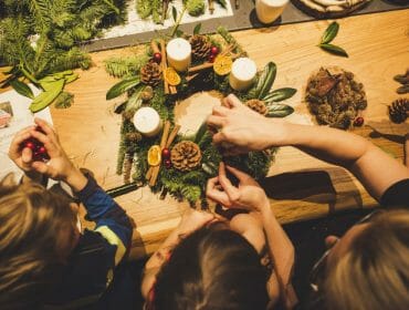 Domácí výroba adventního věnce z přírodnin jako je jehličí, šišky, skořice a sušené plátky citrusů