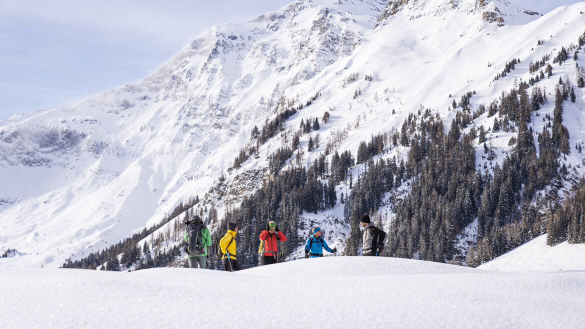 Túry na sněžnicích v okolí Bodenhausu a Kolm Saigurn © Ferienregion Nationalpark Hohe Tauern, Branislav Rohal Skupina turistů na sněžnicích v zasněžené horské krajině u Bodenhausu (Zvětšený pohled)