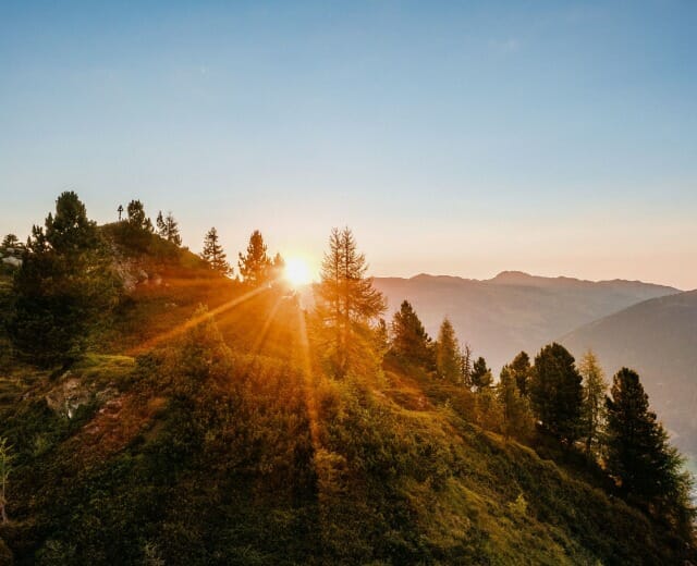 Slunce zapadá za hory ve Wildkogel-Areně