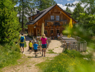 54516844770_6e5fb6e48c_b Rodina putuje k rustikální dřevěné chatě s venkovním posezením, která je ideální pro dovolená s dětmi.