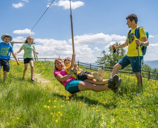 Děti na hřišti na louce v horách