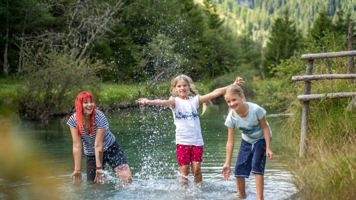Děti dovádějí po výletě v osvěžujícím horském potoce