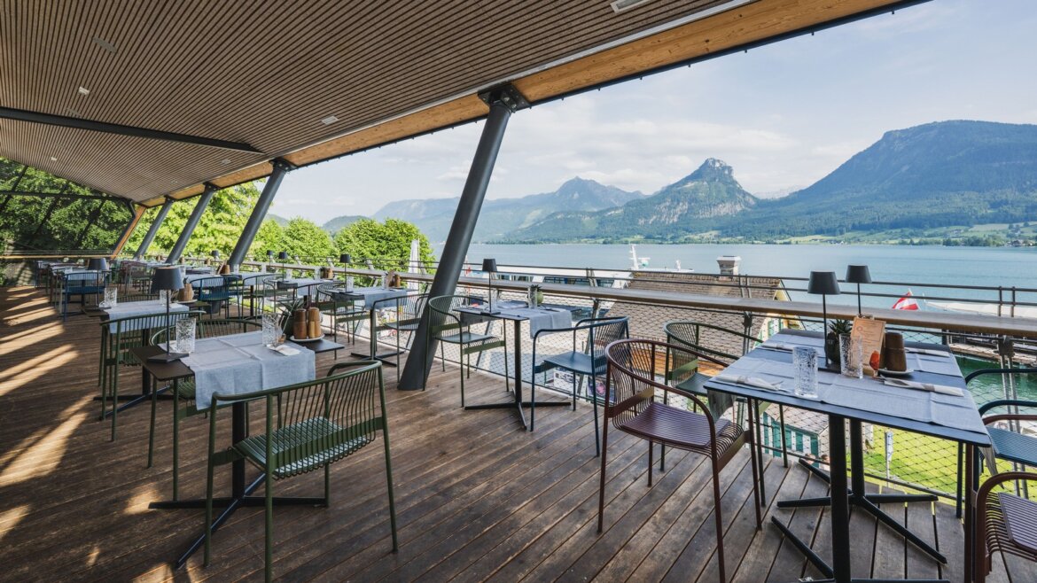 Z restaurace ErlebnisQuartier můžete pozorovat lodě na Wolfgangsee © Salzburg AG Tourismus GmbH Terasa restaurace ErlebnisQuartier za jasného počasí s výhledem na jezero Wolfgangsee (Zvětšený pohled)