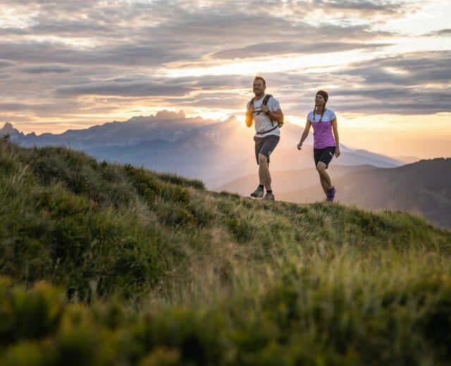 Turistika v Salcburském sportovním světě Výstup po zelené pastvině na horu Hochgründeck s barevnými slunečními paprsky
