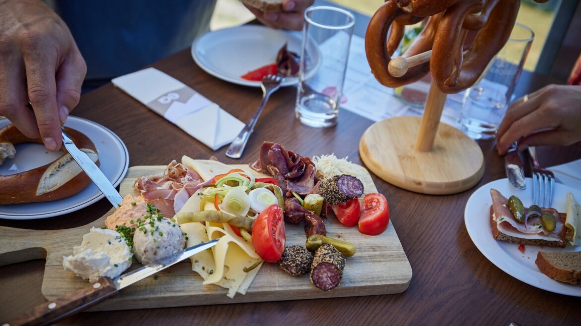 V horské chatě na vrcholu Schafbergu si dáte tradiční svačinu © Salzburg AG Tourismus GmbH Dřevěná tabule se sýry, masem a chlebem na stole u vlaku Zubačka Schafbergbahn. (Zvětšený pohled)