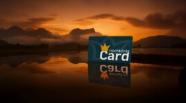 Karta Hochkönig Card stojí na zrcadlícím se jezeře při západu slunce, v pozadí jsou hory.