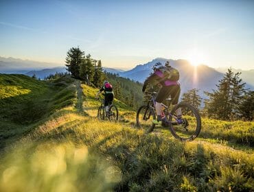 Jízda na kole v horách při východu slunce s pohledem na vrcholy okolních hor