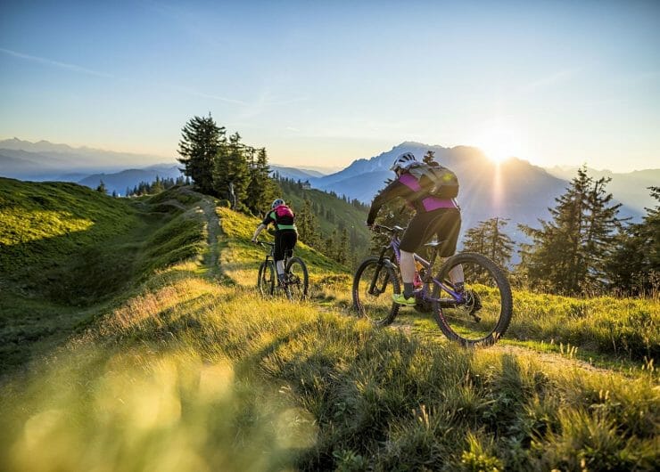 Jízda na kole v horách při východu slunce s pohledem na vrcholy okolních hor