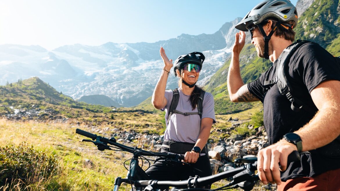 Dva cyklisté si povídají během výletu na horských kolech v alpské krajině v závěru údolí Krimmler Achental