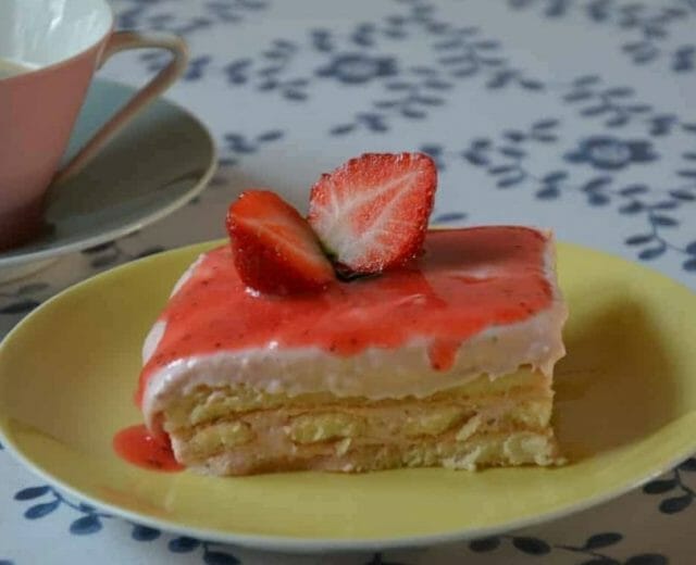 Tiramisu s jahodovo-tvarohovým krémem a jahodovým přelivem, servírované s kousky nakrájených čerstvých jahod