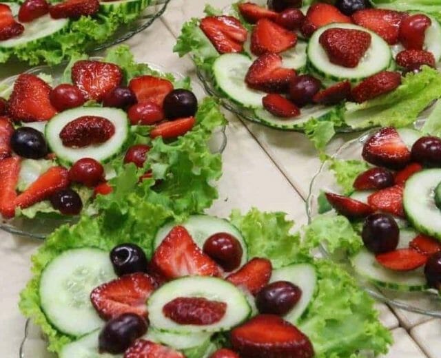 Svěží salát s plátky okurek, nakrájenými jahodami a třešněmi, ochucené aromatickým koprem a citronem