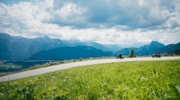 Motorkáři jedou po silnici Postalmstraße a obdivují výhled na okolní hory