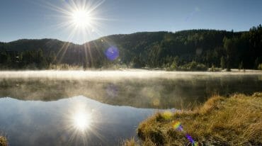 Jezero Prebersee za svitu slunce, kdy se nad vodní hladinou objevuje tajemný mlžný opar bílé barvy