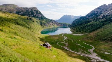 Idylická alpská krajina s pohořím, salaší a modrým jezerem Tappenkarsee