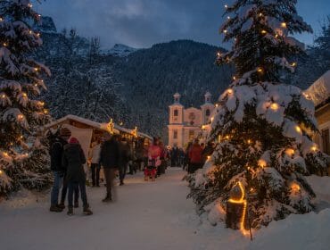 Adventní trh u poutního kostela Maria Kirchental v Salcburském Saalachtalu má romantickou atmosféru díky výzdobě a osvětlení