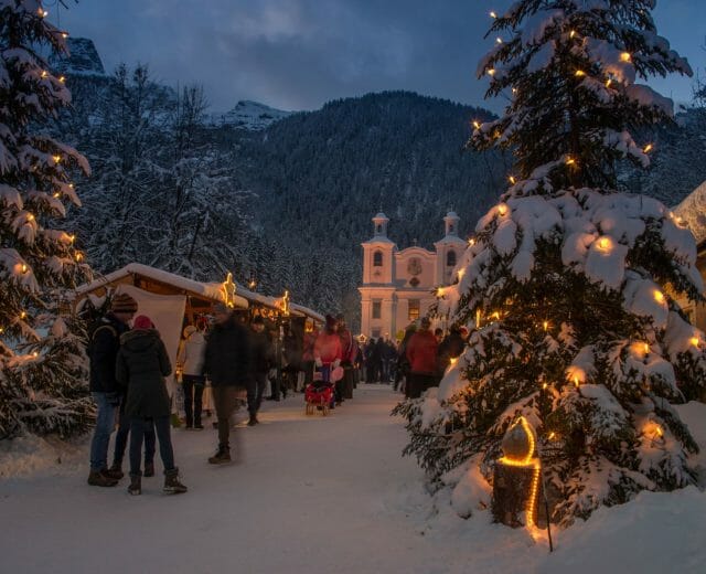 Adventní trh u poutního kostela Maria Kirchental v Salcburském Saalachtalu má romantickou atmosféru díky výzdobě a osvětlení