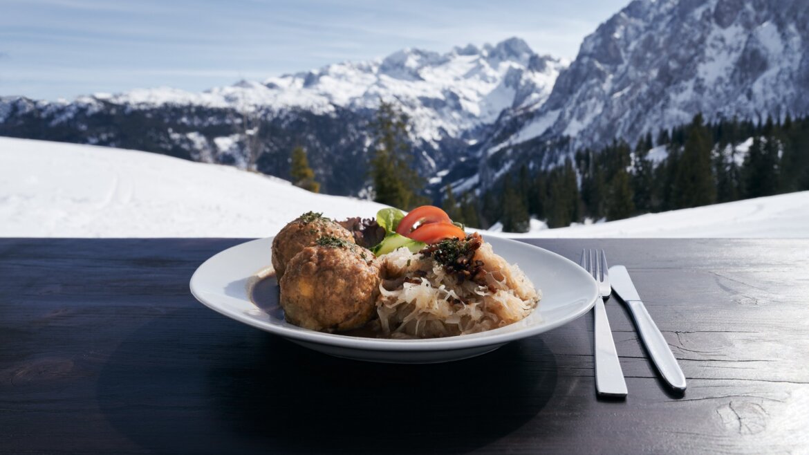 Knedlíky se zelím a oblohou na terase s výhledem na zasněžené hory Dachstein West