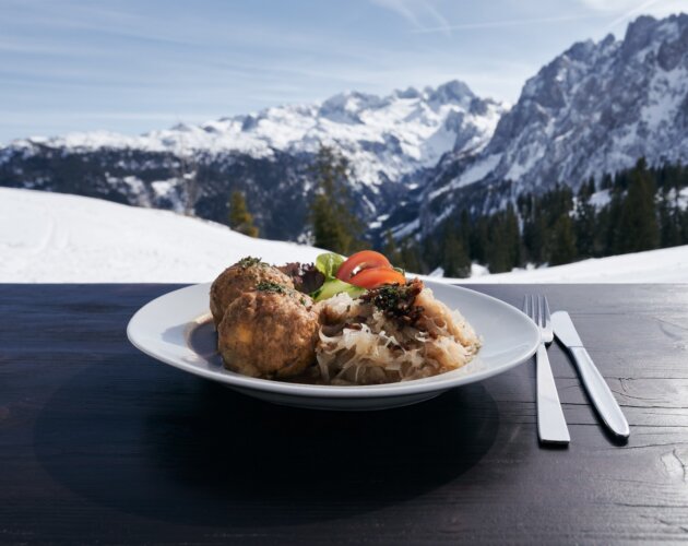 Knedlíky se zelím a oblohou na terase s výhledem na zasněžené hory Dachstein West