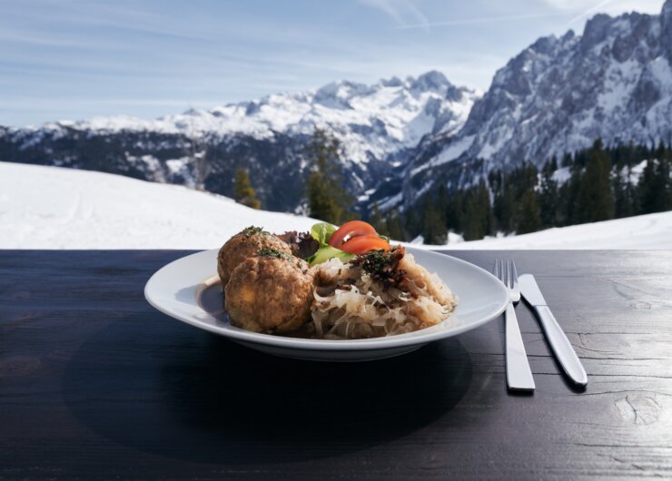 Knedlíky se zelím a oblohou na terase s výhledem na zasněžené hory Dachstein West