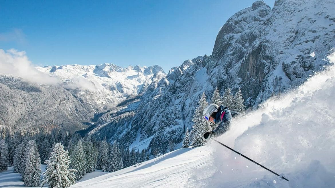 Jízda prašanem na lyžích mezi zasněženými alpskými štíty pod azurovou oblohou v regionu Dachstein West, kde jsou samozřejmostí nejnovější vleky, kvalitní infrastruktura a pohodová rodinná atmosféra