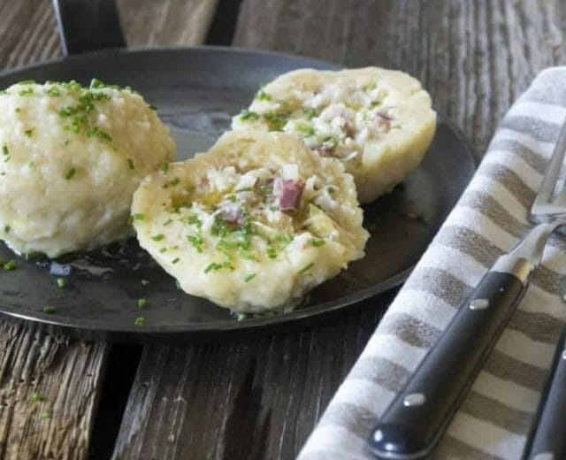 Knedlíky z bramborového těsta chutnají výborně, když se naplní směsí kysaného zelí, tvarohu a posypou se zelenými bylinkami jako například petržel nebo pažitka