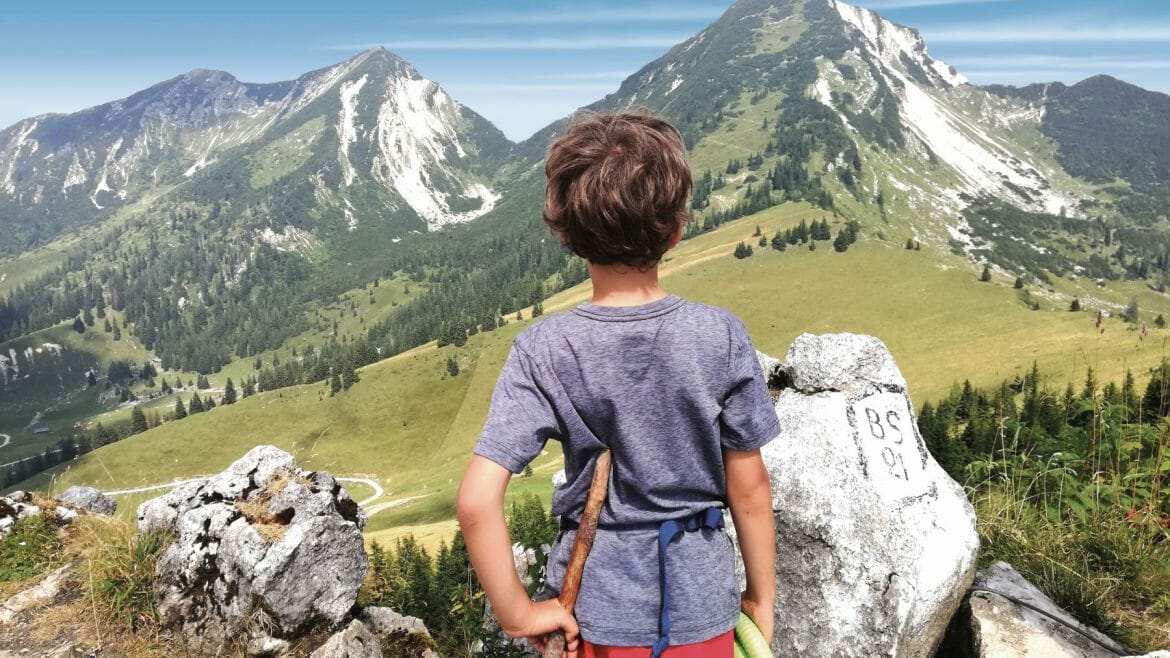 Chlapec se rozhlíží do krajiny hor v turistické oblasti Unken v Salcburském Saalachtalu