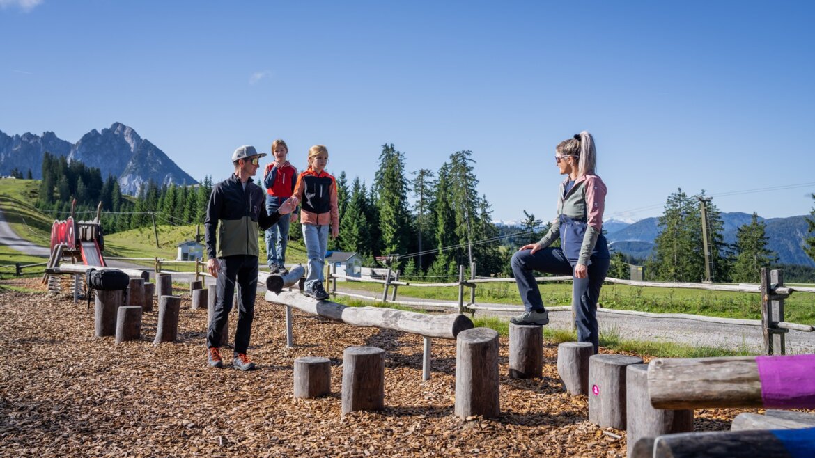 Dospělí a děti si užívají balanční prvky v Brunově světě na Hornspitzu během rodinné dovolené v Dachstein West. (Zvětšený pohled)