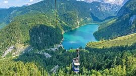 Lanovka Gosaukammbahn nad modrým jezerem a zelenými vrcholky jehličnanů