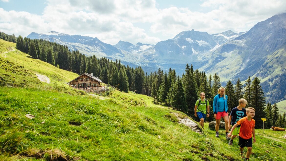Turisté putují okolo chaty Mitterastenalm na idylickém místě uprostřed Národního parku Vysoké Taury. (Zvětšený pohled)