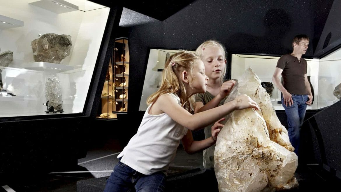 Děti si prohlížejí velký minerál, který je jedním z exponátů muzea ve městečku Bramberg, známém nalezišti smaragdů 