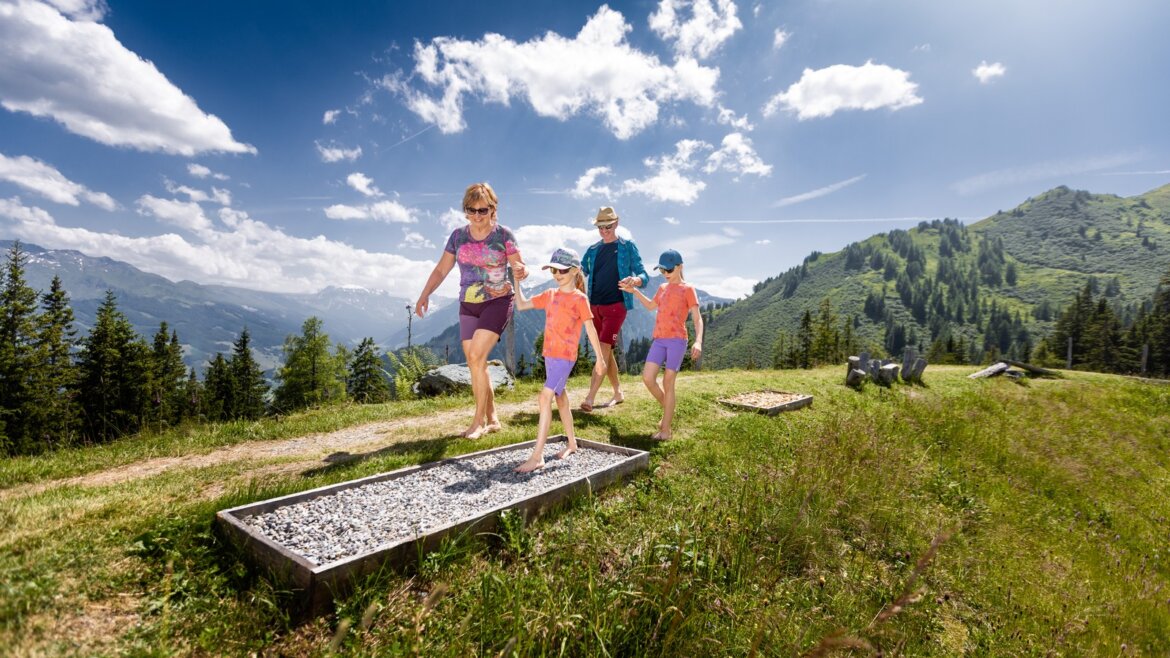 Rodina se prochází naboso po štěrkové cestě na Hochalmu (Zvětšený pohled)