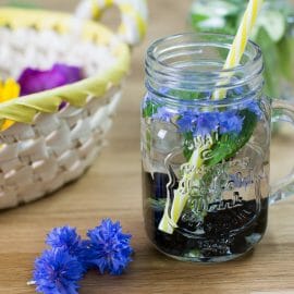 Letní limonáda s bylinkami podávaná ve sklenici s brčkem