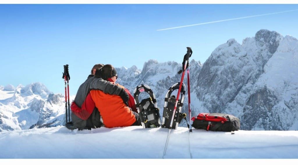 Turisté si odložili sněžnice a odpočívají s výhledem na hory ve středisku Zwieselalm v Dachstein West 