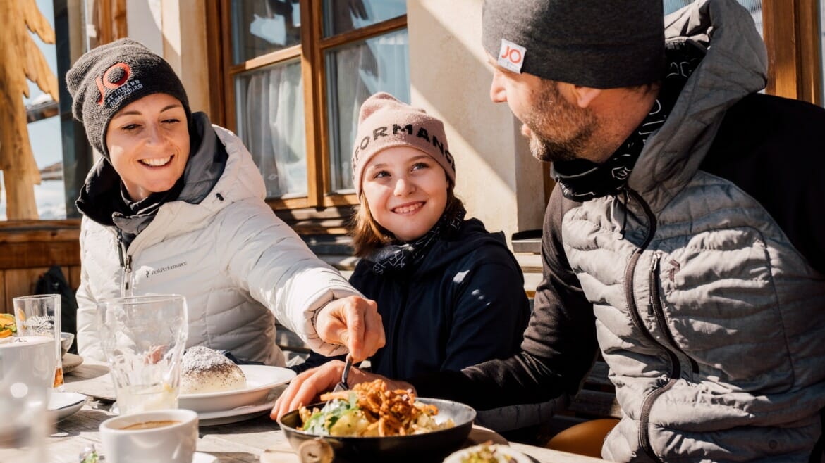 Rodina na obědě na lyžařské chatě v St. Johann v Salcbursku
